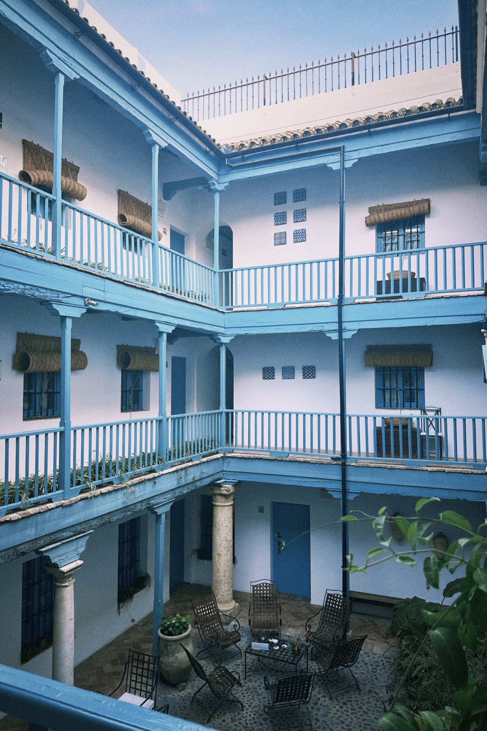 The whitewashed courtyard of Las Casas del Rey de Baeza with two storeys of blue painted galleries